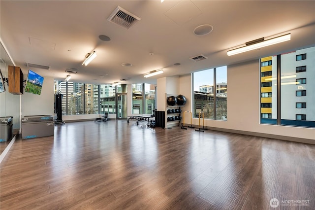 gym featuring floor to ceiling windows, visible vents, and wood finished floors