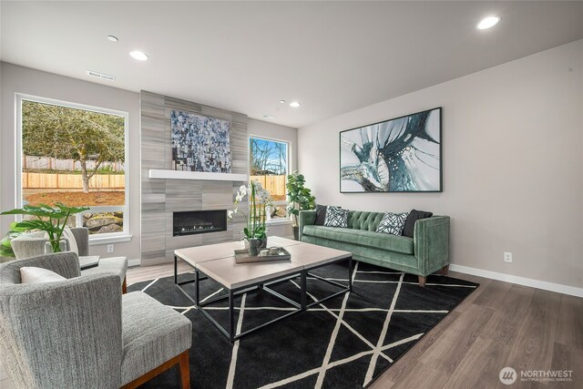 living area featuring baseboards, visible vents, wood finished floors, a fireplace, and recessed lighting