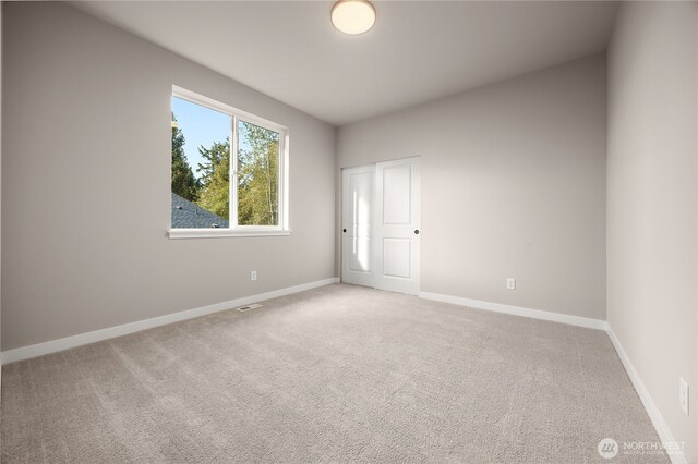 unfurnished bedroom with carpet flooring, visible vents, and baseboards