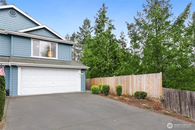 garage with driveway and fence