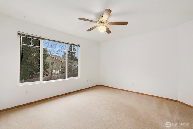 spare room featuring ceiling fan, carpet, and baseboards