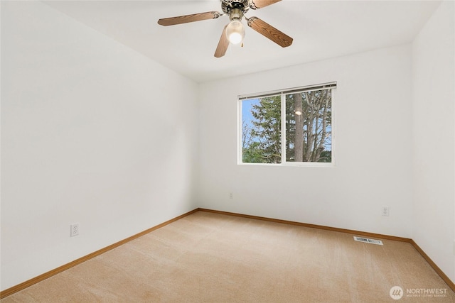 unfurnished room featuring carpet flooring, ceiling fan, visible vents, and baseboards