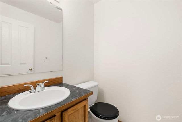 half bath featuring toilet and vanity