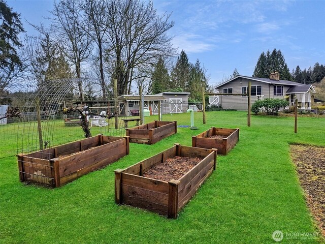 exterior space with an outbuilding, a yard, fence, and a garden