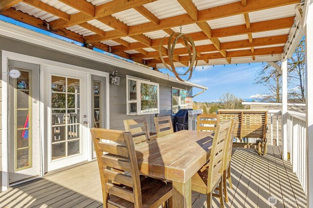 wooden deck with a grill and outdoor dining space