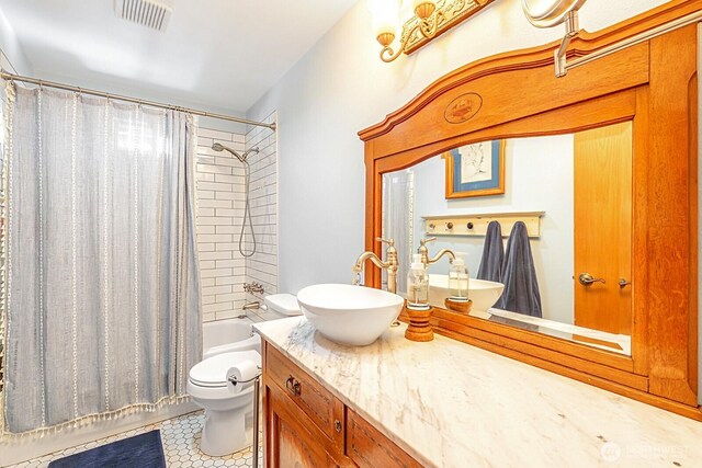 full bathroom featuring visible vents, vanity, toilet, and shower / bath combo with shower curtain