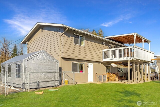 back of house with a deck, a yard, fence, and a gate