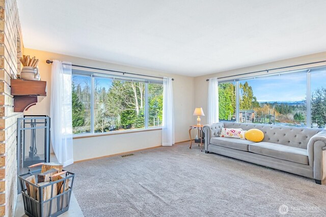 living room featuring a wealth of natural light, carpet flooring, a fireplace, and baseboards