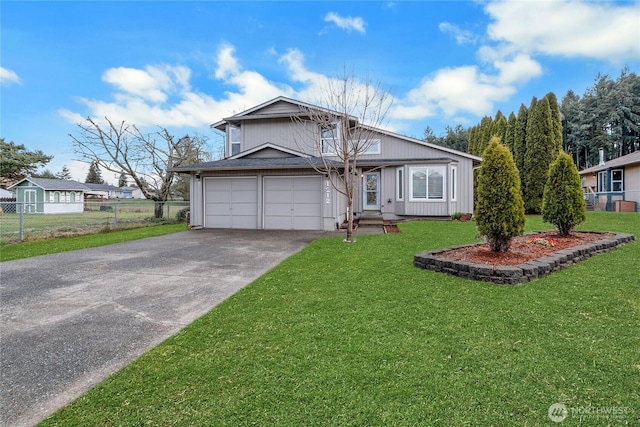 view of front of home featuring a garage, driveway, a front yard, and fence