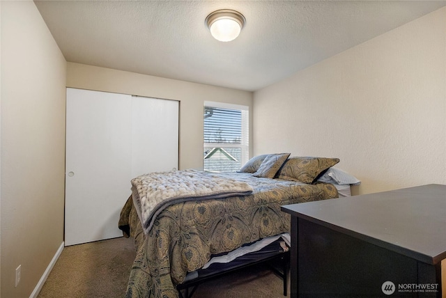 bedroom with a textured ceiling, baseboards, and carpet flooring