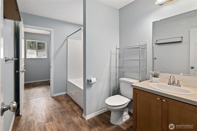 bathroom featuring vanity, baseboards, toilet, and wood finished floors