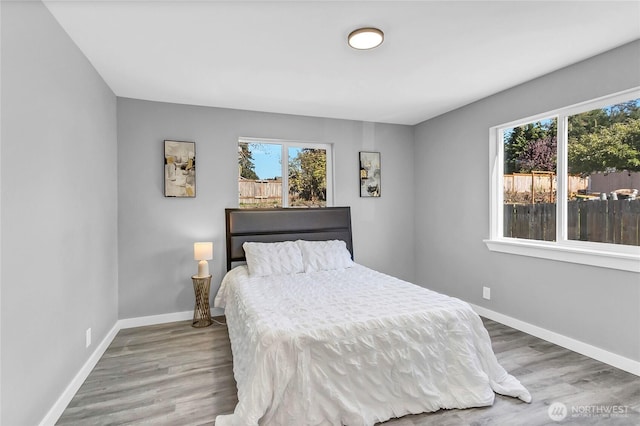 bedroom with multiple windows and wood-type flooring