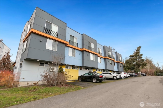 view of property with uncovered parking and a residential view