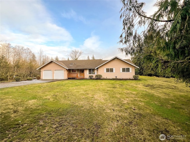 ranch-style house featuring aphalt driveway, a garage, and a front lawn