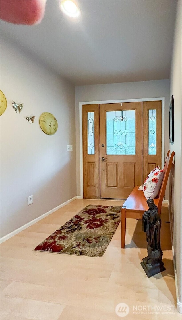 foyer featuring a wealth of natural light, baseboards, and wood finished floors