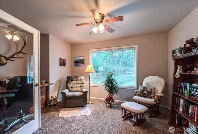 sitting room featuring a ceiling fan, baseboards, and carpet flooring