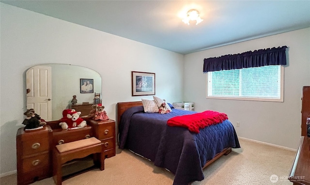 bedroom featuring baseboards, arched walkways, and light colored carpet