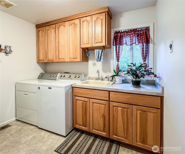 clothes washing area featuring cabinet space, visible vents, a sink, and independent washer and dryer