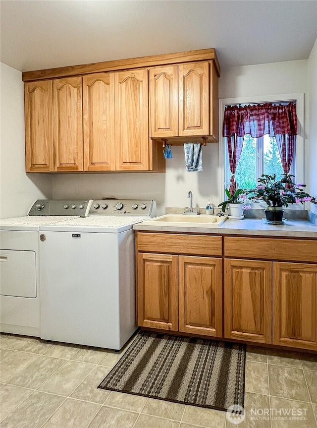 clothes washing area featuring cabinet space, a sink, washer and clothes dryer, and light tile patterned floors