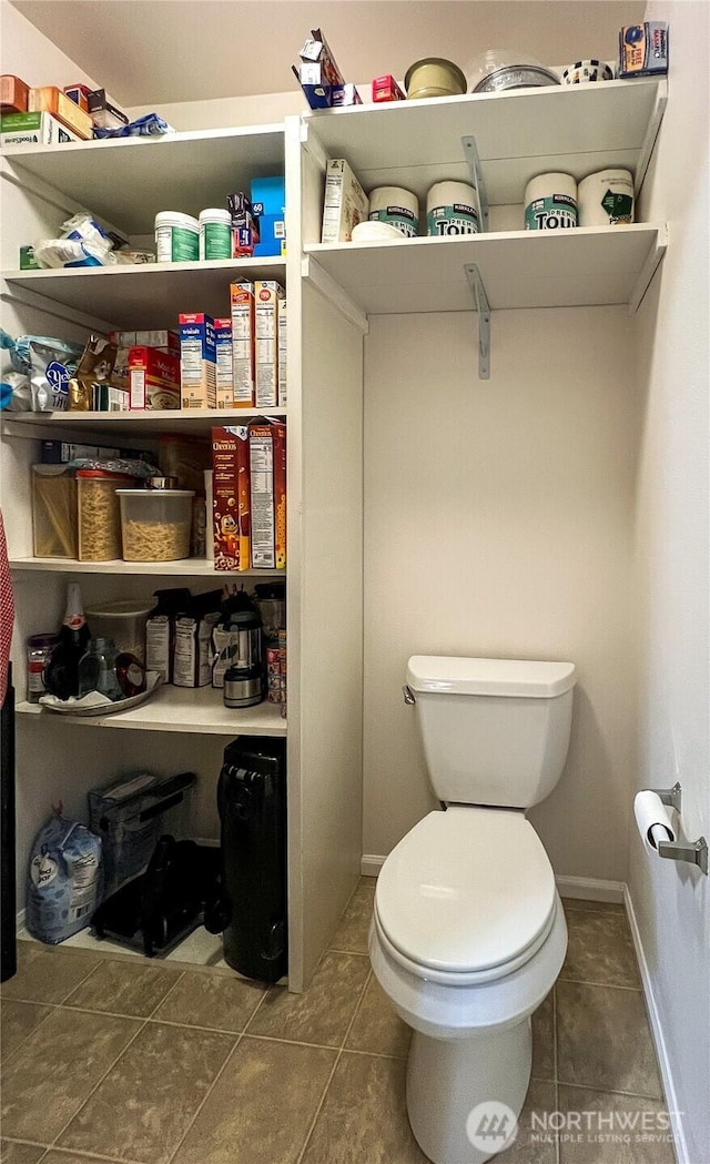 bathroom with tile patterned flooring, toilet, and baseboards