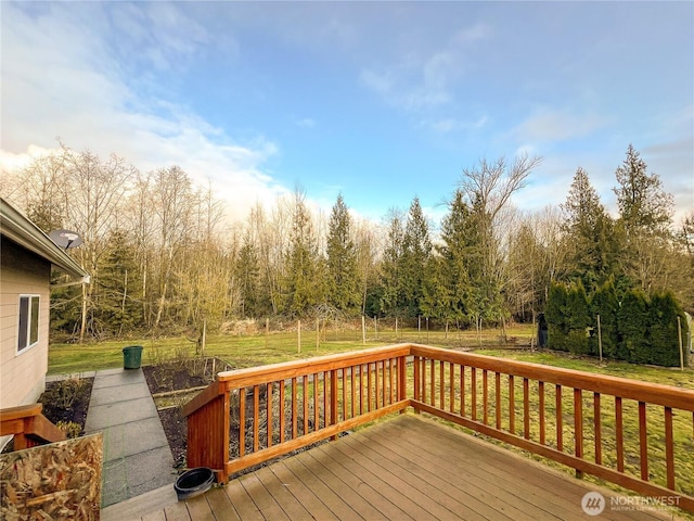 wooden deck featuring a lawn