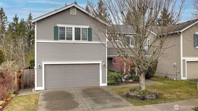 traditional home featuring an attached garage, driveway, fence, and a front yard