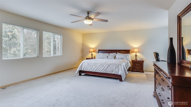 bedroom featuring light carpet, ceiling fan, visible vents, and baseboards