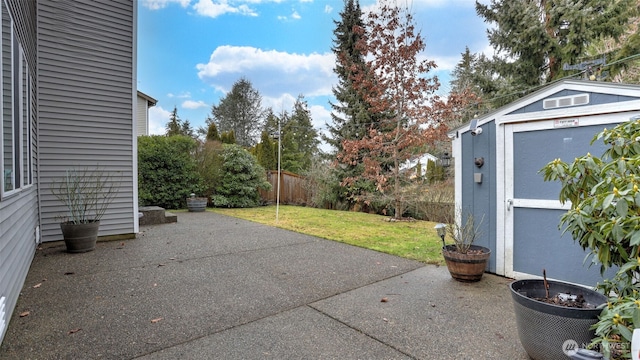 view of patio with a storage shed, fence, and an outdoor structure