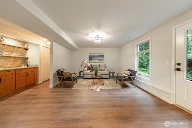 living area featuring light wood-type flooring and baseboards