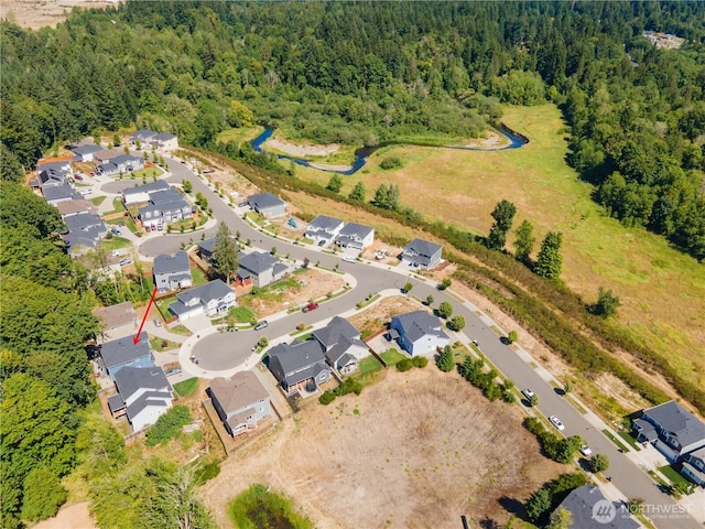 drone / aerial view featuring a forest view and a residential view