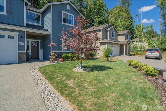 traditional-style home with a garage, stone siding, driveway, and a front lawn