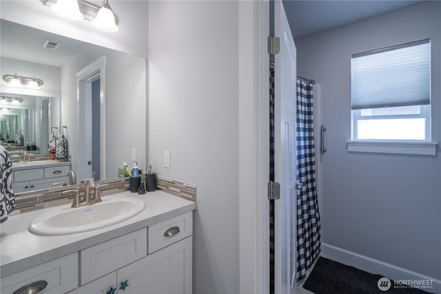 full bathroom with curtained shower, vanity, visible vents, and baseboards