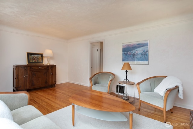 living area with light wood-type flooring and baseboards