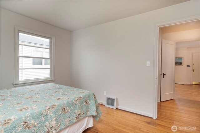 bedroom with light wood-style floors, baseboards, and visible vents