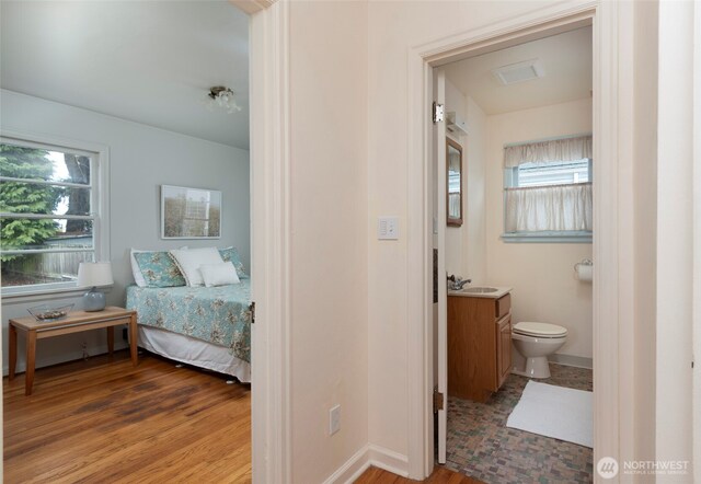 interior space with toilet, wood finished floors, vanity, and baseboards