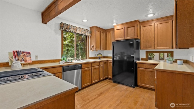 kitchen featuring freestanding refrigerator, stainless steel dishwasher, light countertops, brown cabinetry, and light wood-style floors