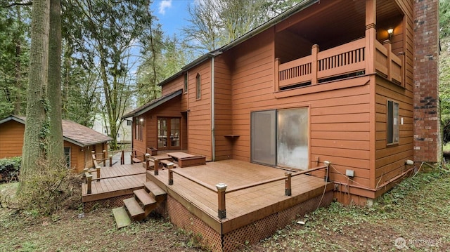 rear view of property with a balcony and a deck