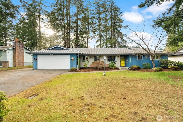 ranch-style home with a front lawn, a standing seam roof, metal roof, concrete driveway, and a garage