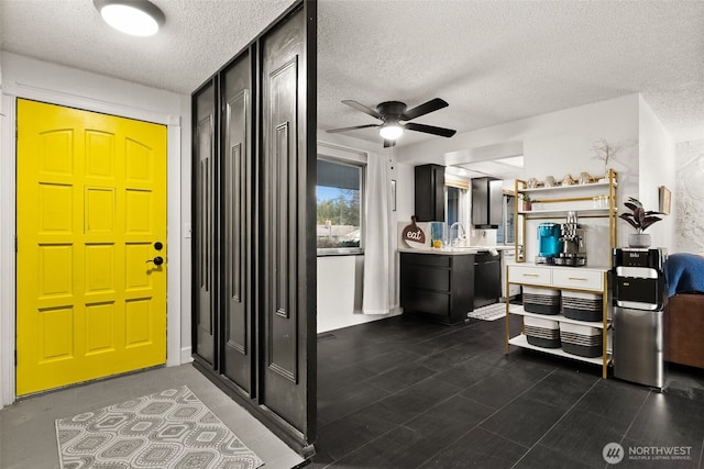 entrance foyer featuring a ceiling fan and a textured ceiling