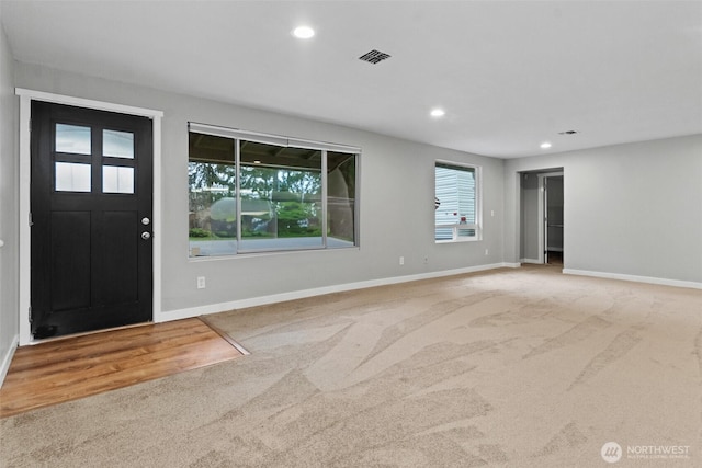 carpeted entryway featuring baseboards, visible vents, and recessed lighting