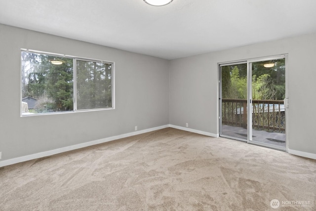 carpeted spare room featuring baseboards