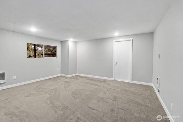 below grade area featuring recessed lighting, light carpet, and baseboards