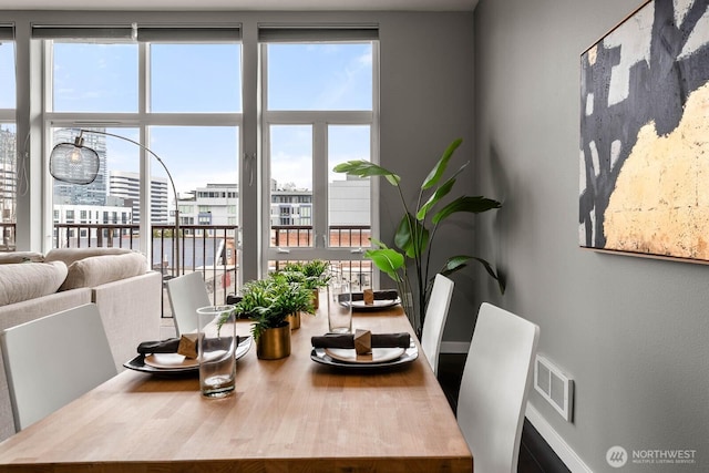 dining space with visible vents, a city view, and a wealth of natural light