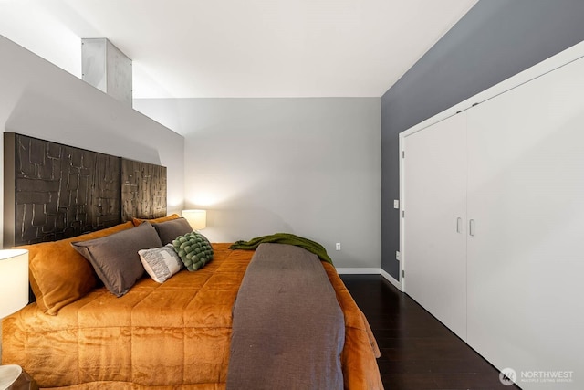 bedroom with lofted ceiling, a closet, and wood finished floors