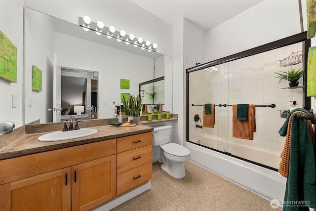 full bath with combined bath / shower with glass door, vanity, and toilet