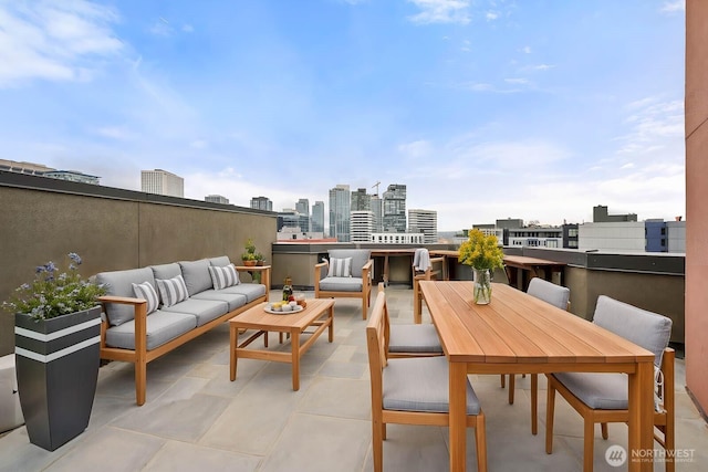 view of patio / terrace featuring a view of city, outdoor lounge area, and outdoor dining space