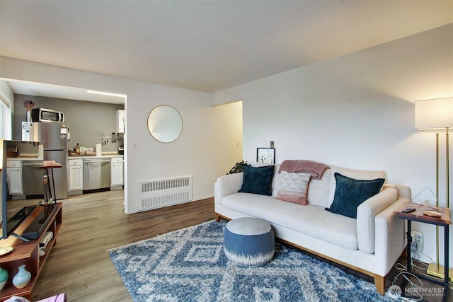 living room featuring radiator heating unit and light hardwood / wood-style floors