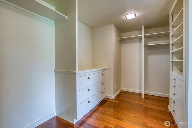 walk in closet with wood finished floors