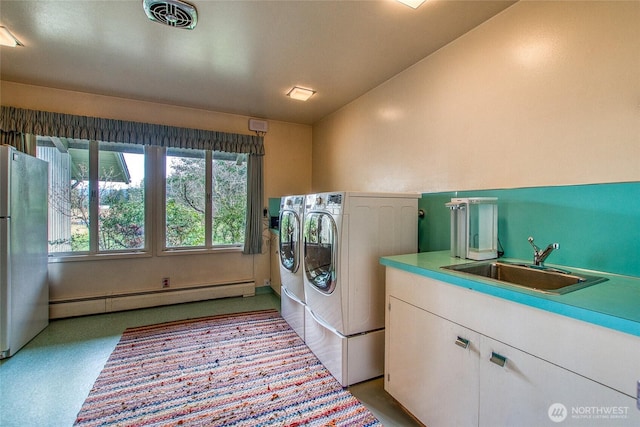 laundry room featuring separate washer and dryer, a sink, visible vents, laundry area, and baseboard heating
