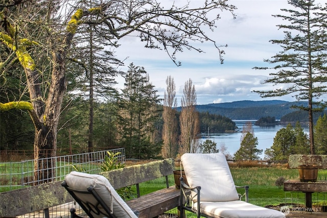 exterior space featuring a wooded view and a water view